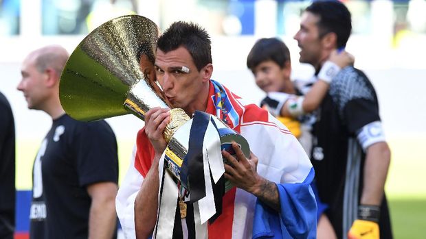 Mario Mandzukic TURIN, ITALY - MAY 21: Mario Mandzukic of Juventus FC celebrates with the trophy after beating FC Crotone 3-0 to win the Serie A Championships at the end of the Serie A match between Juventus FC and FC Crotone at Juventus Stadium on May 21, 2017 in Turin, Italy. (Photo by Valerio Pennicino/Getty Images)
