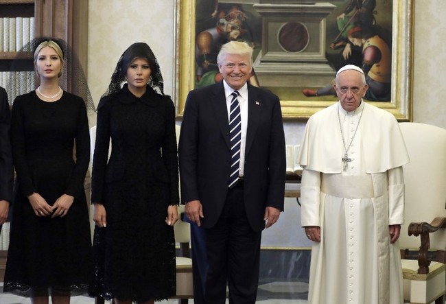 Melania kembali jadi perhatian ketika ia memakai kerudung hitam lace saat datang ke Vatikan. Netizen banyak menjadikannya meme karena penampilannya tampak seperti hantu. Bahkan foto ini disamakan dengan foto keluarga The Addams Family, serial Amerika dari tahun 1991. Foto: AFP PHOTO / POOL / Evan Vucci