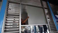 Petugas menutup kaca-kaca halte yang pecah dengan alumunium flanel.