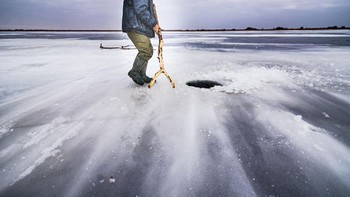 Para pemenang akan diumumkan pertengahan tahun. Fotografer Popescu Cezar Gabriel memotret seorang nelayan dari Delta Danube, ketika melintasi danau Gorgova. Dia  menemukan lebih dari 20 lubang es yang memiliki kedalaman 200 meter. Foto ini diambil ketika fajar pada suhu di bawah nol derajat celcius. (Foto: National Geographic/Popescu Cezar Gabriel)