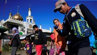Warga dengan membawa barang-barang berjalan di sepanjang jalan utama untuk melanjutkan ke pusat evakuasi di luar kota Marawi setelah pasukan pemerintah melanjutkan serangan terhadap kelompok militan terkait ISIS yang telah mengambil alih sebagian besar kota Marawi, Filipina, Jumat (26/5/2017). REUTERS/Romeo Ranoco