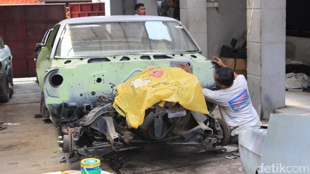 Pekerja bengkel Fix Garage tengah merestorasi mobil klasik