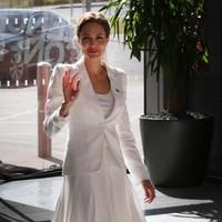 Tampil elegan dengan setelan blazer dan rok serba putih. Foto: Getty Images