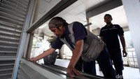 Petugas mengukur kaca halte TransJakarta yang pecah akibat bom.