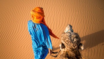 Masing-masing juara akan mendapatkan hadiah uang tunai, untuk posisi pertama USD 25,000, posisi kedua USD 750 dan sebuah buku tandangan National Geographic dan ketiga USD 500. Foto ini karya Benjamin Dugone ketika ia menaiki seekor unta lalu memotret pria yang mengiringi perjalanannya. (Foto: National Geographic)