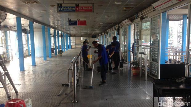 Petugas membersihkan halte