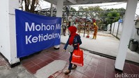 Seorang penumpang tengah melintas saat pengerjaan perbaikan di Stasiun Klender.