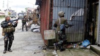 Tentara Filipina memeriksa bangunan di sepanjang jalan yang mereka lintasi. Erik De Castro/Reuters.