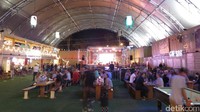 Sementara untuk pertunjukan konser, sudah disediakan area The Paddock. Di sana ada panggung konser dan meja-meja kayu panjang. Kita bisa makan sambil mendengarkan penampilan musik di panggung (Fitraya/detikTravel)