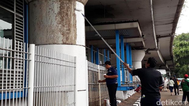 Petugas tengah membenahi halte TransJ Kampung Melayu sebelum dioperasikan kembali