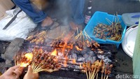 Campuran arang dan batok dengan kepulan api jadi bahan bakar untuk membakar sate. Sate ayam dan sate sapi dibakar hingga kecokelatan.