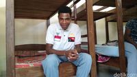 Marianus mengenakan polo shirt Indonesia-Papua Nugini di asrama sekolahnya.