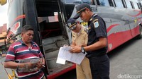 Petugas memeriksa surat-surat bus.