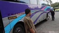 Petugas memeriksa ban bus.