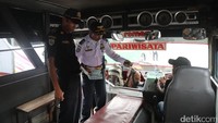 Petugas memeriksa bagian dalam bus.