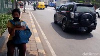 Seorang pedagang uang receh menanti pembeli.
