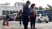 Dengan hanya bermodalkan bangku dan tas besar, mereka duduk dan membawa gepokan uang receh sejak pukul 09.00WIB. Mereka menawarkan uang-uang receh itu kepada setiap orang yang melewatinya.