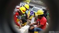 Pekerja melebarkan pedestrian di Jalan Jatinegara Timur.