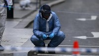 Petugas forensik melakukan investigasi di lokasi kejadian. REUTERS/Neil Hall.