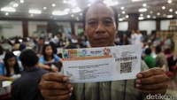 Seorang warga menunjukan tiket mudik gratis yang telah didapatkanya.