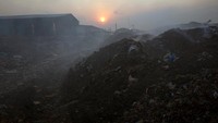 Matahari tenggelam terlihat sangat indah. Namun dengan suasana gunungan sampah di Hanoi, Vietnam, tentu menjadi hal yang berbeda. REUTERS/Kham.