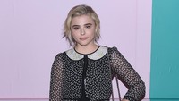 Bintang film Carrie itu tampak manis dengan dress cute dan tas yang simple. Foto: Roy Rochlin/Getty Images