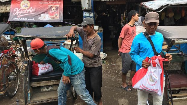 Selain paket sembako, Presiden Jokowi membagi-bagikan kaos dan buku tulis.