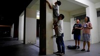 Layaknya sebuah tim, mereka bahu membahu selama kegiatan berburu semut. Sampai naik-naik ke atas dinding pun dilakukan demi mendapatkan semut yang diincar (Edgar Su/Reuters)