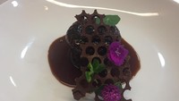 Sticky toffee pudding dilengkapi toffee sauce dan dilengkapi cokelat bentuk honey comb dan edible flower sebagai hiasannya.