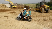 Pengendara sepeda motor melintas di proyek Tol Pejagan-Pemalang seksi III dan IV.