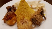Nasi Kuning Tumpeng Mini berbentuk kerucuT. Pelengkapnya ayam goreng, perkedel, telur balado, orak arik tempe dan emping. Nasinya sedikit hambar, kurang ada citarasa menonjol.