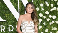 Chrissy Teigen tampil menawan dengan strapless gaun berwarna putih yang menunjukan lekuk tubuhnya. Dimitrios Kambouris/Getty Images for Tony Awards Productions/detikFoto.