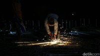 Seorang pekerja mengelas rangka beton.