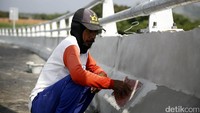 Seorang pekerja mengecat pagar pembatas flyover Klonengan.