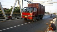 Pemburu koin menanti para pengguna jalan memberikan uangnya di sisi kanan dan kiri jembatan.