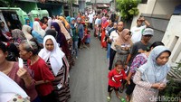 Warga Duren Sawit, Jakarta Timur, antre untuk mendapatkan bingkisan yang berisi kebutuhan pokok, Selasa (13/06/2017).