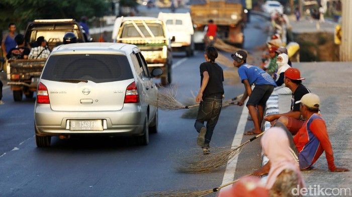 Para penyapu uang sawer mengambil uang-uang koin dari pengendara di Jembatan Sewo, Pantura, Indramayu, Jabar. Mereka seakan tidak peduli akan keselamatannya.