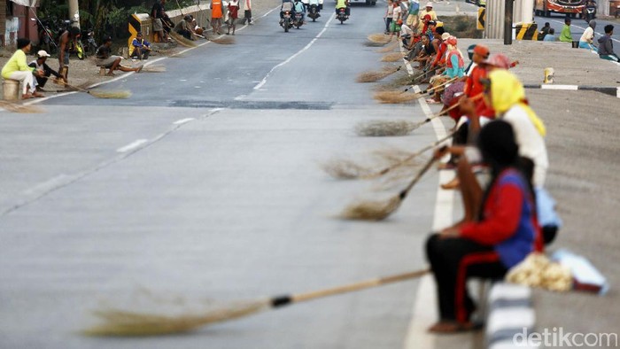 Para penyapu uang sawer mengambil uang-uang koin dari pengendara di Jembatan Sewo, Pantura, Indramayu, Jabar. Mereka seakan tidak peduli akan keselamatannya.