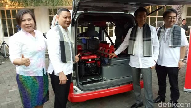 Manajemen Nissan berpose di mobil servis