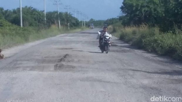  Dinas Pekerjaan Umum Siak, Riau menyiagakan alat berat di jalan nasional yang rusak.