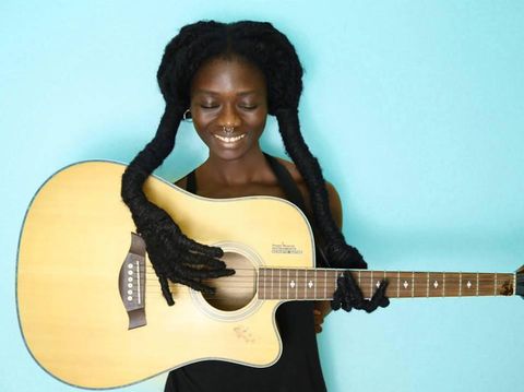Rambut Laetitia Ky pose tangan memetik gitar. 