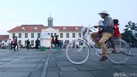 Ada yang berkeliling dengan sepeda tua.