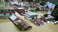 Sebagian rumah yang terendam banjir hanya terlihat atapnya. Reuters TV.