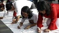 Peserta aksi membubuhkan tanda tangan dukungan kepada KPK.