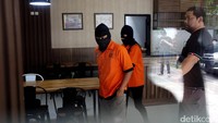  Para tersangka dihadirkan dalam rilis dengan memakai baju tahanan dan penutup kepala.