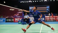 Tontowi berusaha menjangkau shuttlecock.