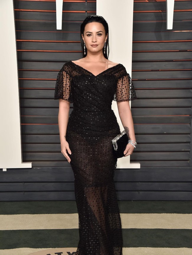 Demi Lovato menunjukkan sisi anggunya di karpet merah Vanity Fair Oscar Party 2016 dalam balutan gaun hitam Dolce & Gabbana. (Foto: Getty Images)