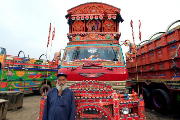 Supir yang sedang berpose di depan truk . Warna-warna yang terdapat pada truk menampilkan ciri khas daerah tertentu lho! (Caren Firouz/REUTERS) Supir yang sedang berpose di depan truk . Warna-warna yang terdapat pada truk menampilkan ciri khas daerah tertentu lho! (Caren Firouz/REUTERS)