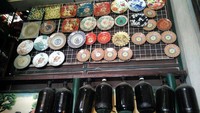 Di Pasar Triwindu, ada juga yang menjual piring keramik hias yang ditempel di dinding. Di bawahnya, ada botol-botol besar bekas menyimpan cairan kimia. Unik ya? (Wahyu/detikTravel) Di Pasar Triwindu, ada juga yang menjual piring keramik hias yang ditempel di dinding. Di bawahnya, ada botol-botol besar bekas menyimpan cairan kimia. Unik ya? (Wahyu/detikTravel)