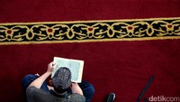 Seorang warga tengah membaca alquran.